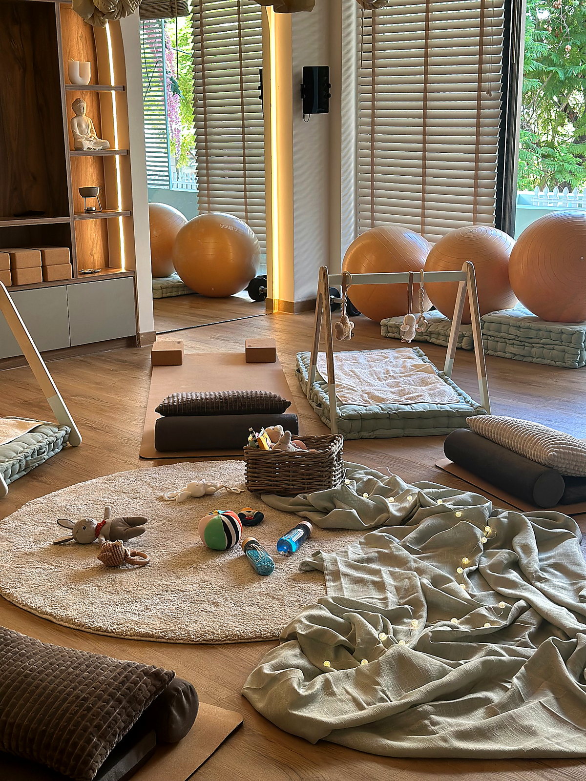 Η αίθουσα στρωμένη για μάθημα mommy and baby yoga, με χαλάκια, μπάλες και παιχνίδια